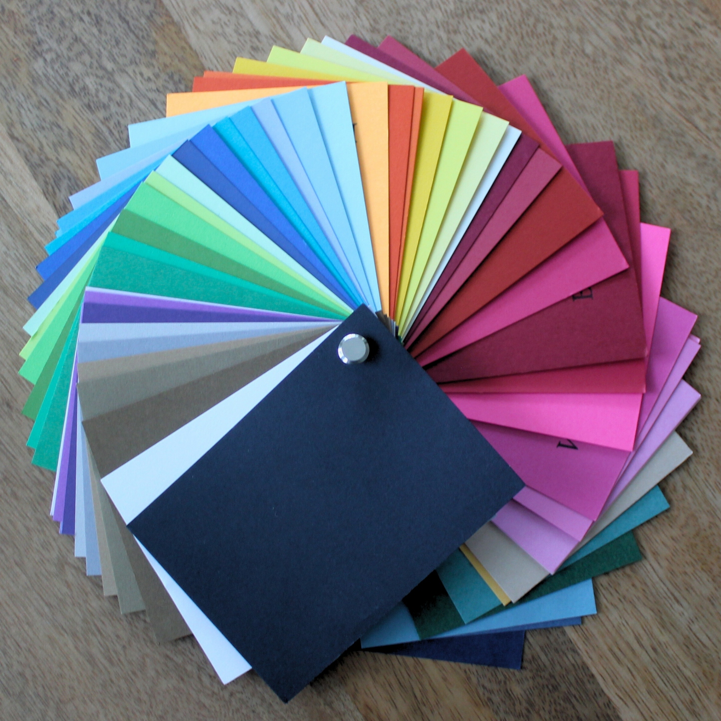 Cardstock swatch book Color swatch chart with various colors on a wooden surface