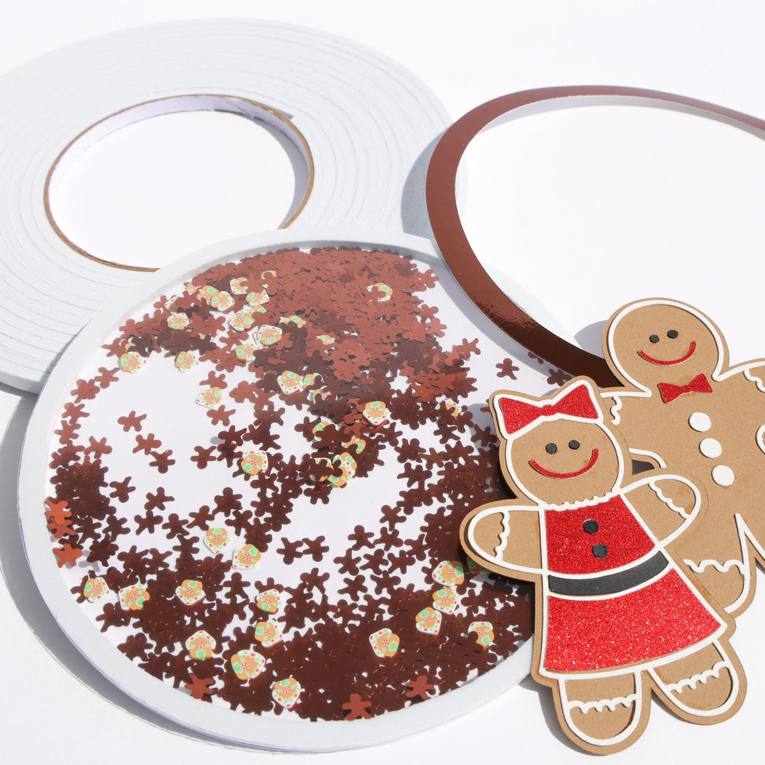 Gingerbread shaker card with brown sequins built with white foam tape, next to a roll of white 3D foam tape
