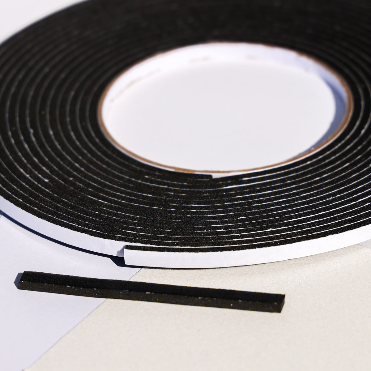 Black double sided 3D foam tape roll with a cut strip for layered cardstock and card making