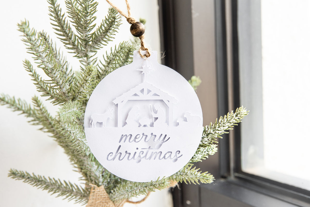 Personalized layered paper ornament with a nativity scene and merry Christmas cut from white cardstock