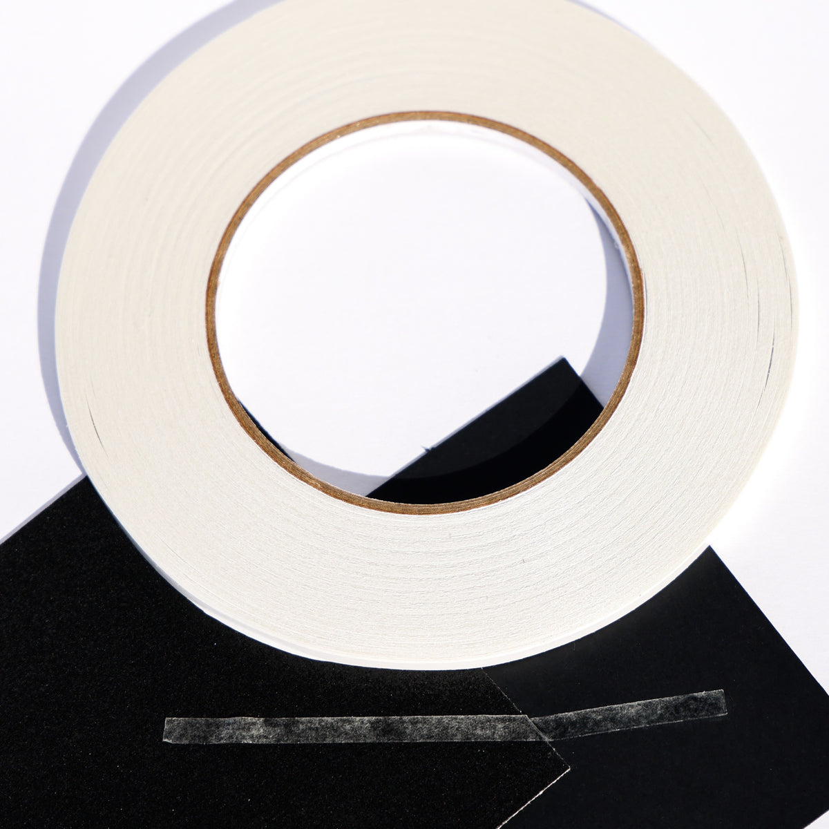 Double sided craft tape roll with clear strips on black cardstock for card making