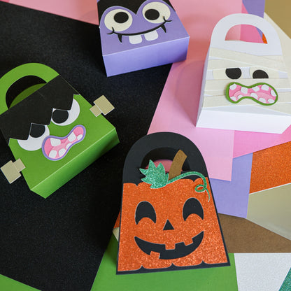 Four finished Halloween boo bags cut from cardstock: Frankenstein, jack-o-lantern, vampire, and mummy