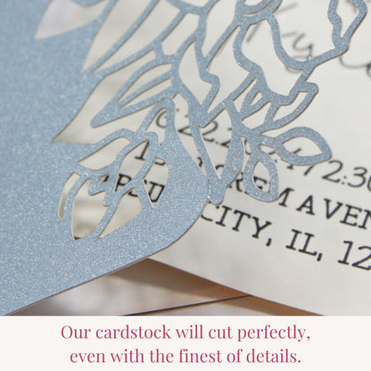 Icy blue glitter cardstock cut with intricate fine detail on a laser cut wedding invitation