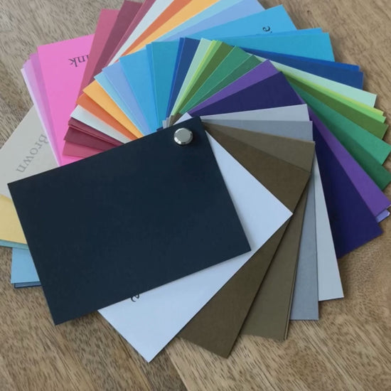 Cardstock swatch book Color swatch chart with various colors on a wooden surface
