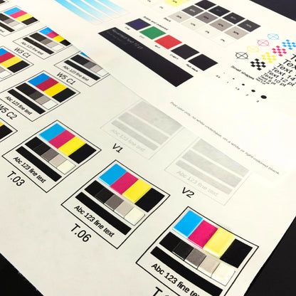 Raised UV printed texture swatches T.03, T.06, and T.10 next to glossy varnish swatches V1 and V2 on the UV printer test grid